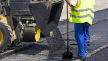 Construction Worker Asphalting a City Road
