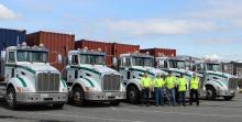 Employees of Castan, Inc. pose in front of trucks that operate at Ports of Tacoma and Seattle