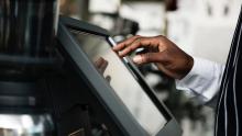 Retail worker taps on a screen to enter an order