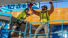 Iron workers secure materials in place during construction of the International Arrivals Facility bridge over the taxiway at Sea-Tac Airport, Seattle, Feb. 26. 2019
