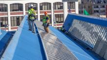 Workers installing solar panels on Pier 69 roof, Port of Seattle, March 19, 2019