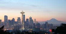 Seattle skyline at sunset with Mount Rainier in the background and Space Needle in the foreground. 