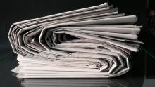 Thick newspaper folded over on a black background