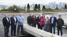 Northwest Seaport Alliance managing members, Directors, Executives, a Local 19 Longshore Worker representative, and SSA Terminal Representative pose at Terminal 5, a container terminal at the Port of Seattle. The group assembled for the groundbreaking project to modernize the terminal.