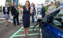 Commissioner Courtney Gregoire with an EV charging station at the airport