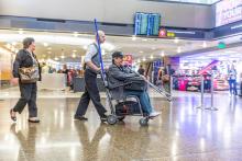 Wheelchair pusher helping passenger