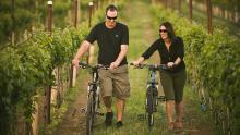 Couple walking bicycles through a winery in Yakima, WA