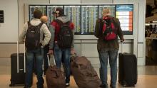 Passengers look at the flight information at SEA Airport, Jan. 2020