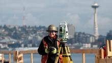 Female construction worker using equipment on Seattle job site