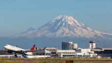 Delta airlines jet takes off from SEA Airport in front of Mt. Rainier 