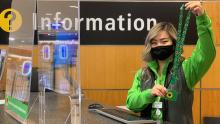 Pathfinder holds up a sunflower lanyard at the SEA information desk