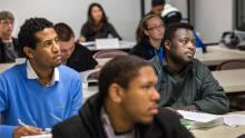 Airport employees in a classroom setting, intently looking at the front of the room