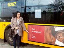 Marin Burnett standing in front of a bus with her artwork on it.
