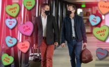 Couple walks together surrounded by candy conversation hearts