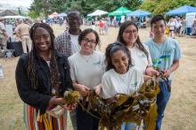 Youth holding seaweed at a Duwamish River event