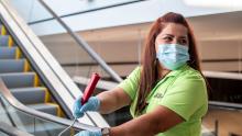 A Custodial Employee wearing a mask while cleaning