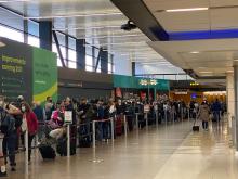 Masked passengers waiting in line at SEA Airport