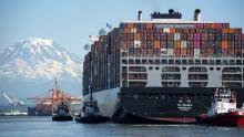 Cargo ship gets piloted by tugs into the Port of Tacoma WA