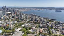 Aerial shot of downtown Seattle with Elliott Bay and various ships on a summer day 2021