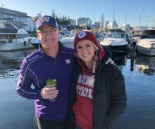Two people celebrating Apple Cup onboard their boat