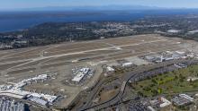 Aerial of sEA Airport on a sunny day looking westward toward the Puget Sound in the distance