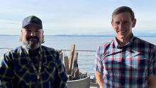 Chad Aldridge and Commissioner Ryan Calkins on the deck of Pier 69 with Elliott Bay in the background