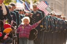 Young girl waves a flag at Veterans Day Parade in New York City