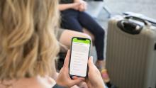 Woman looks at an app on her phone screen at SEA Airport