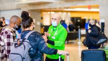 SEA volunteer Joseph Olive directs passengers at the airport.
