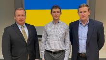 Steve Metruck–Port of Seattle Executive Director Valeriy V. Goloborodko–Honorary Consul of Ukraine and Ryan Calkins–Port of Seattle Commission President pose in front of a Ukranian flag at Port Headquarters