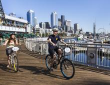 People biking on the Bell Harbor Marina boardwalk