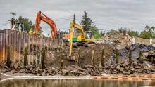 Two excavators move dirt during cleanup at Terminal 117.