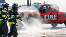 Port of Seattle Fire Department firefighters conducting a fire exercise putting out an electrical vehicle fire on a test vehicle